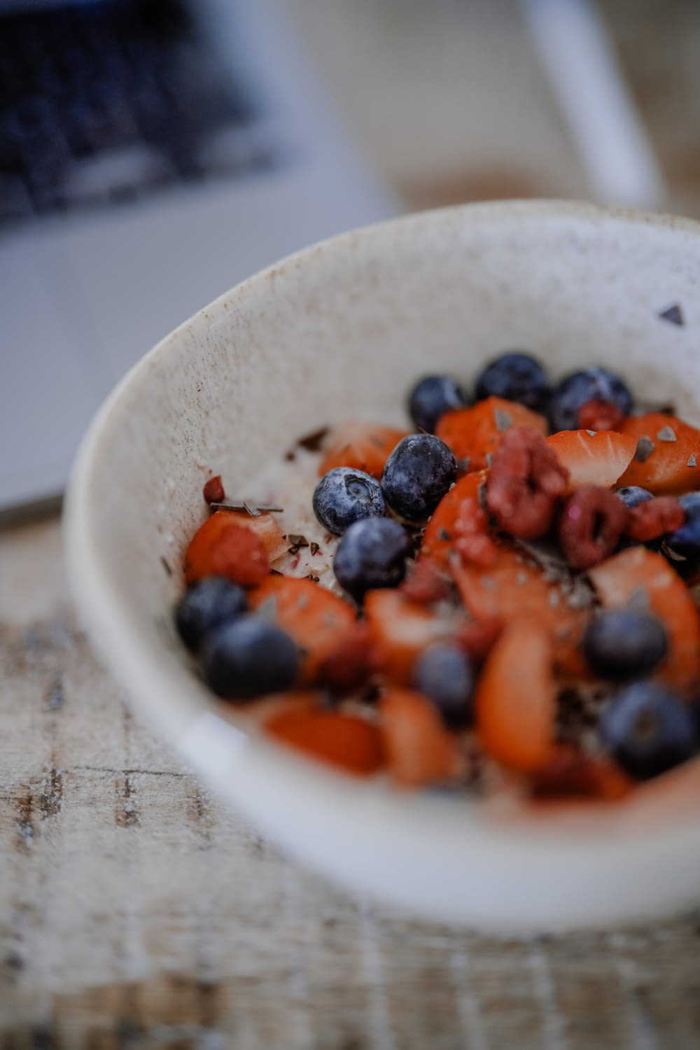 a white bowl filled with blueberries and strawberries