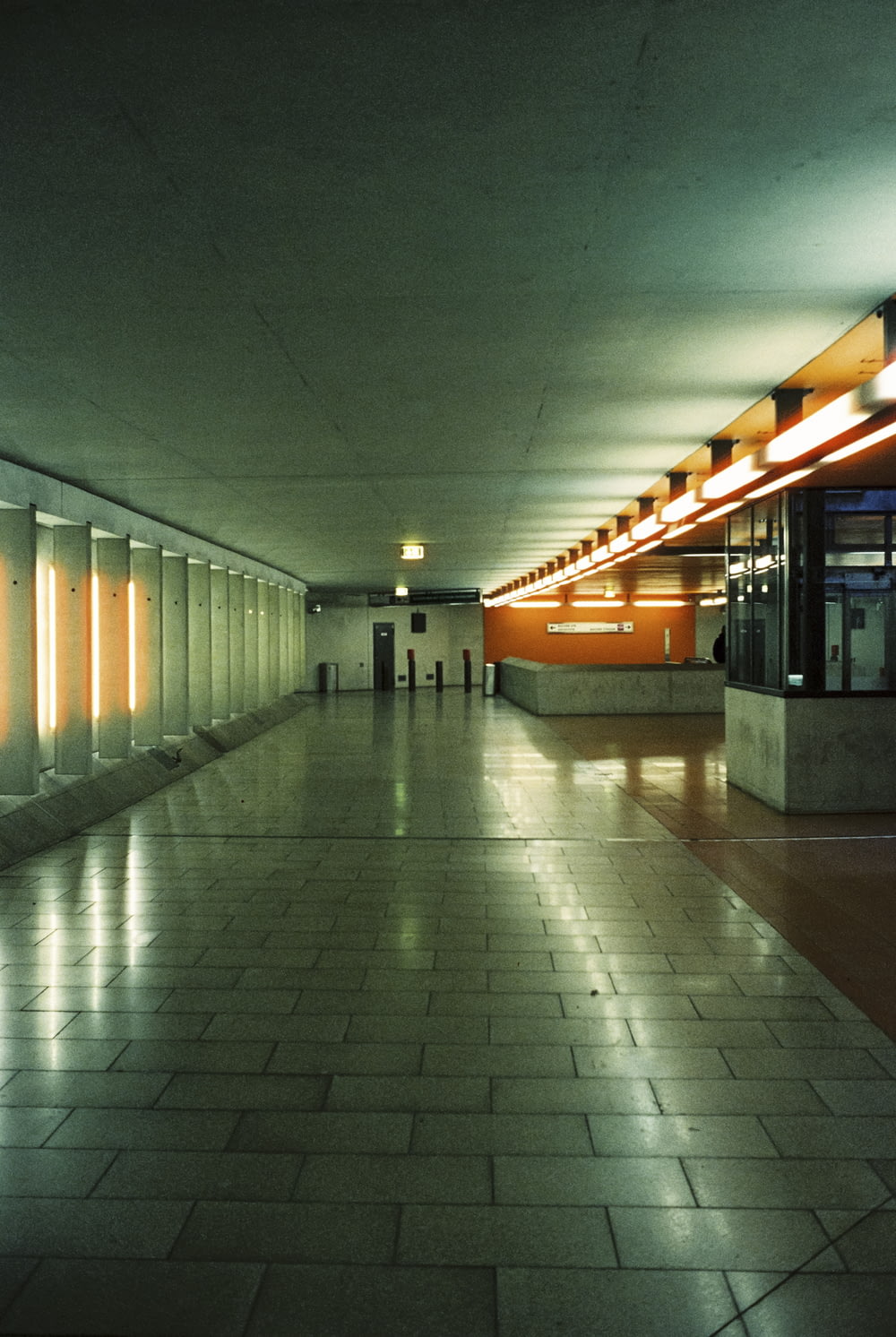 a long hallway with a tiled floor and orange walls