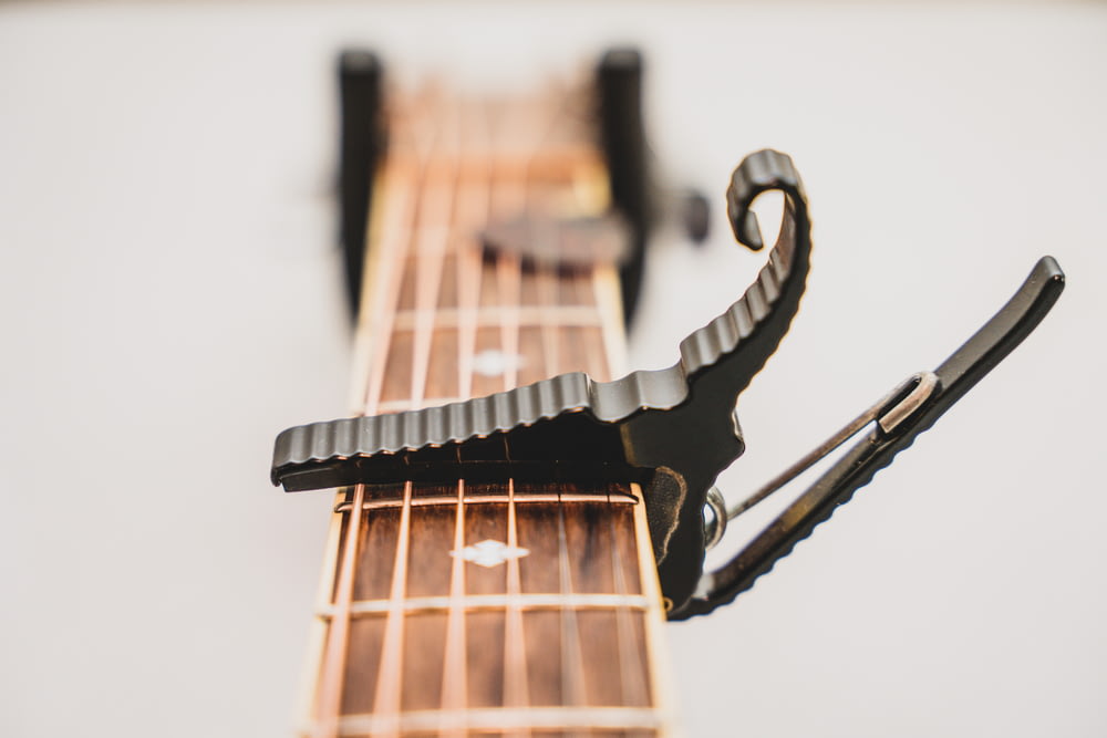 a close up of a guitar's neck with a pair of scissors