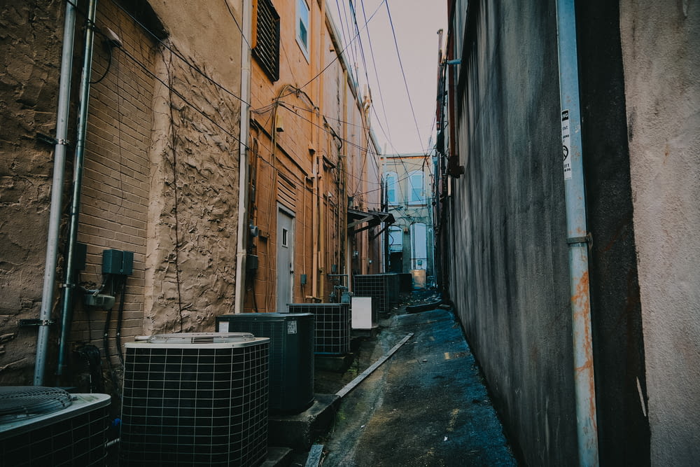 a narrow alley way with air conditioners on either side
