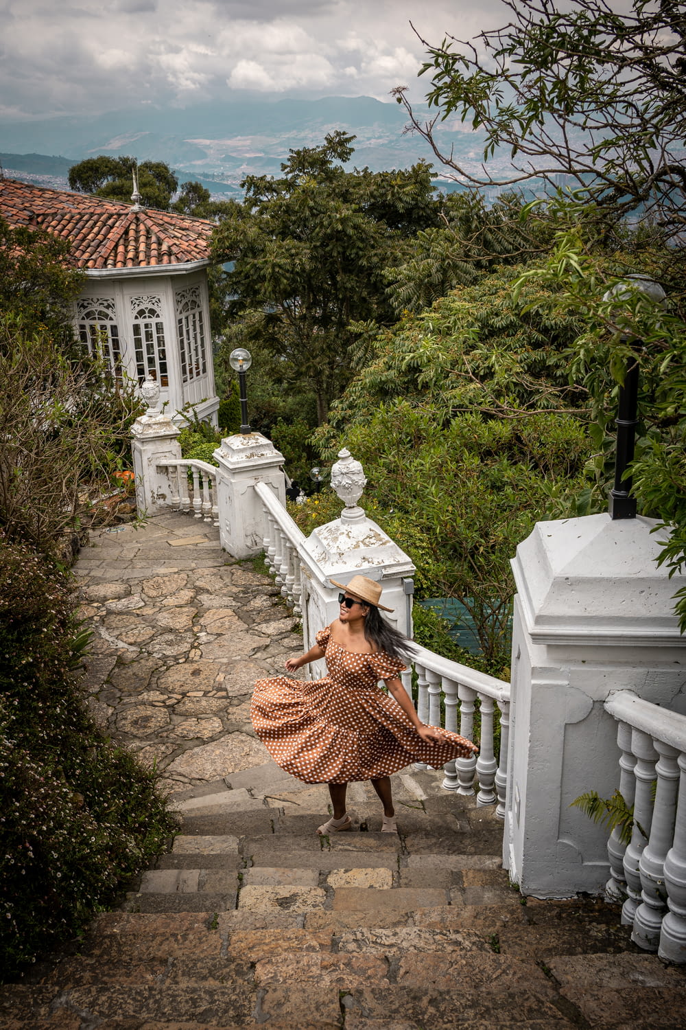 a woman in a dress is walking down a set of stairs