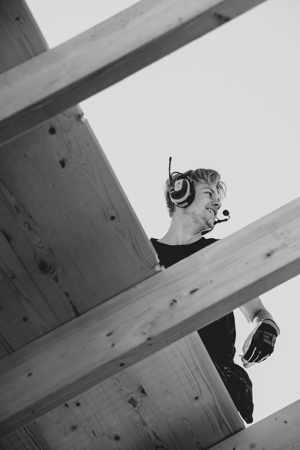 a man wearing headphones standing on top of a wooden structure