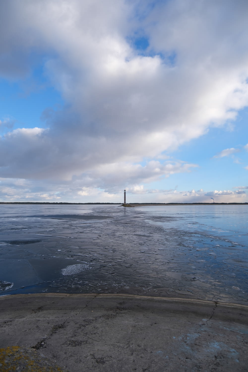 a body of water with a light house in the distance