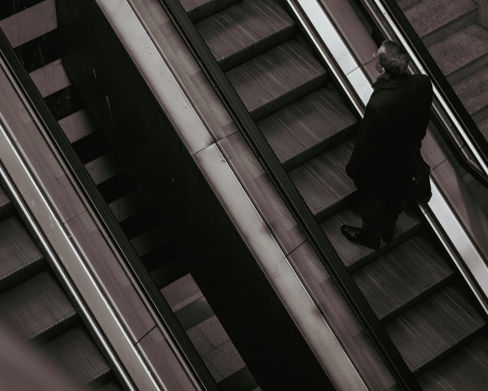 a man walking down an escalator in a building