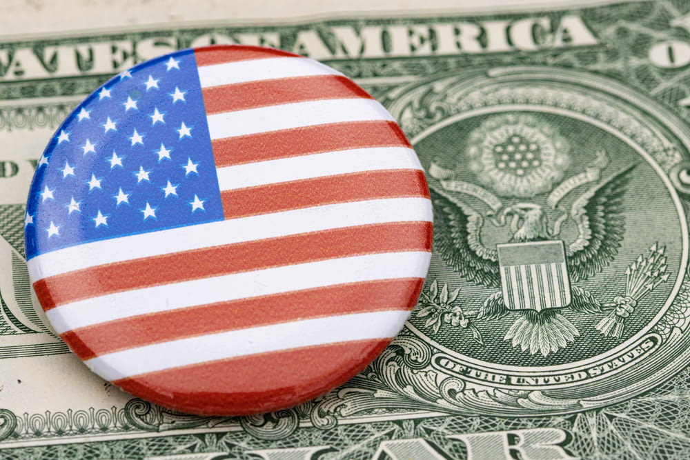 a button with the american flag on top of a dollar bill