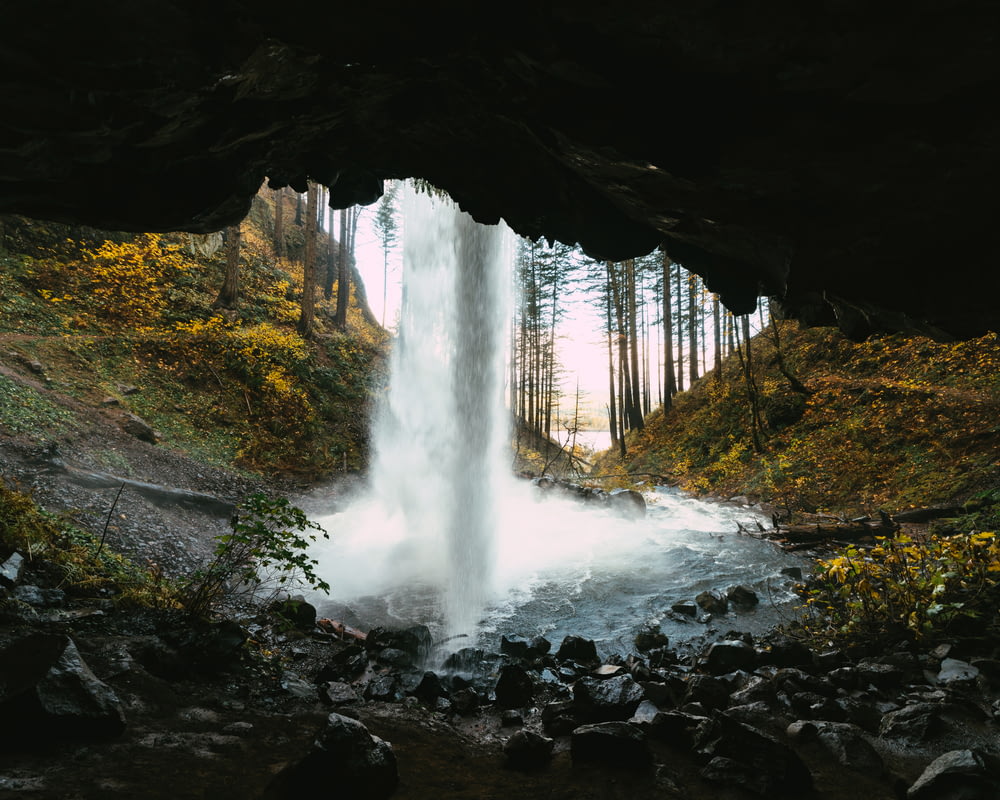 a waterfall is coming out of a cave