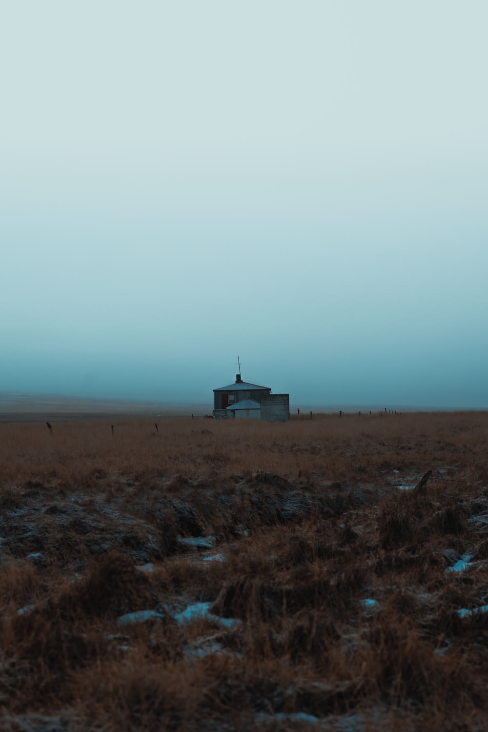 a lone house in a field with a sky background