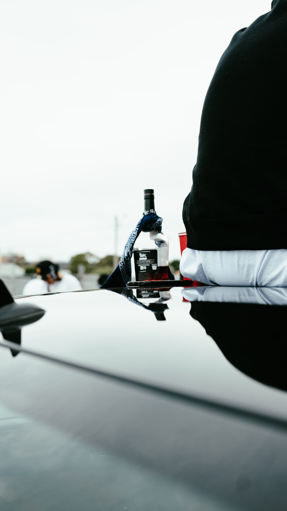 a bottle of alcohol sitting on the hood of a car
