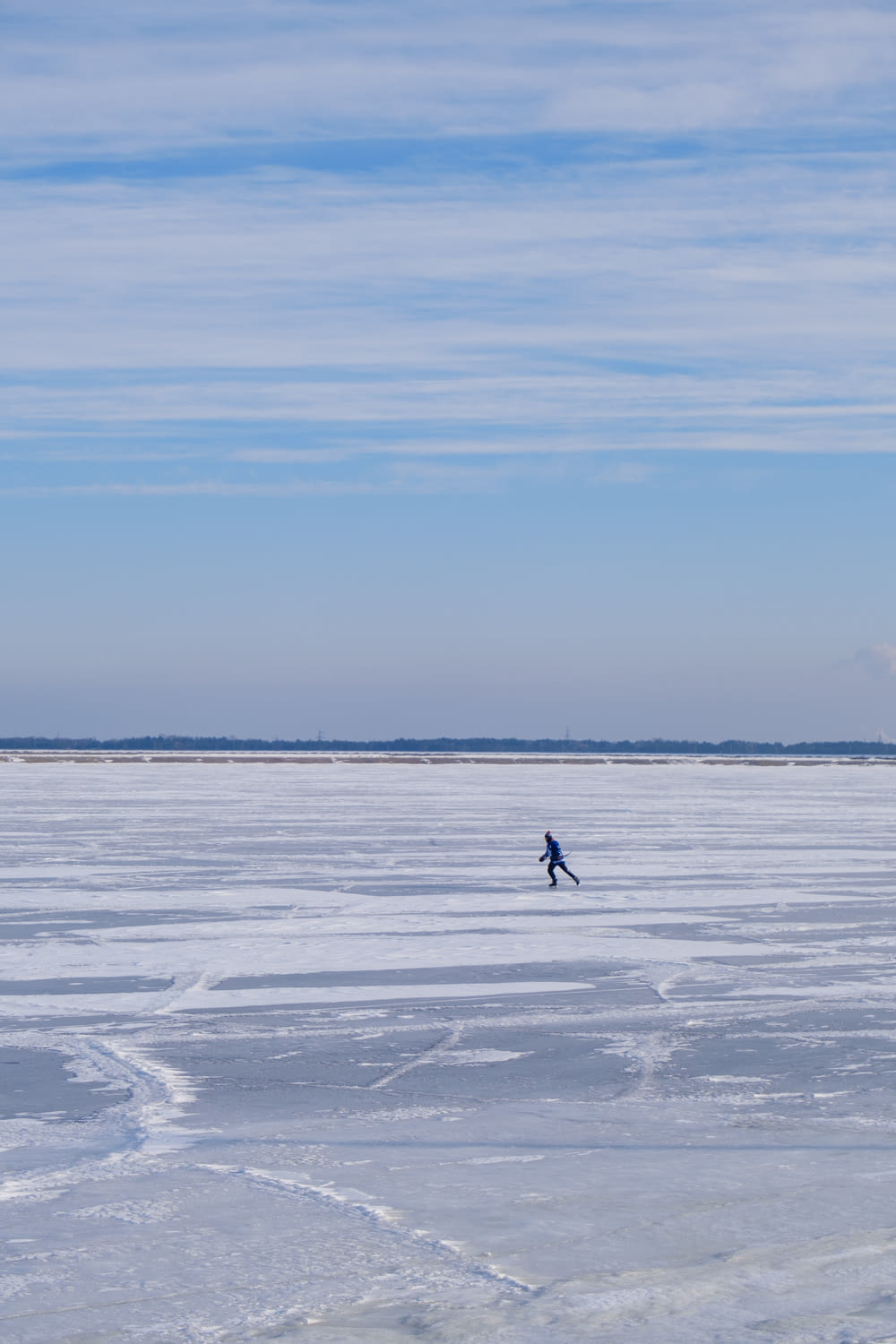 a person walking across a frozen lake on a sunny day