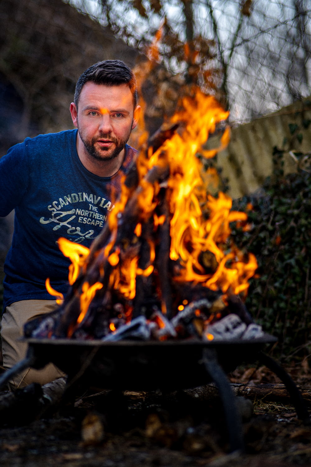 a man sitting in front of a fire pit