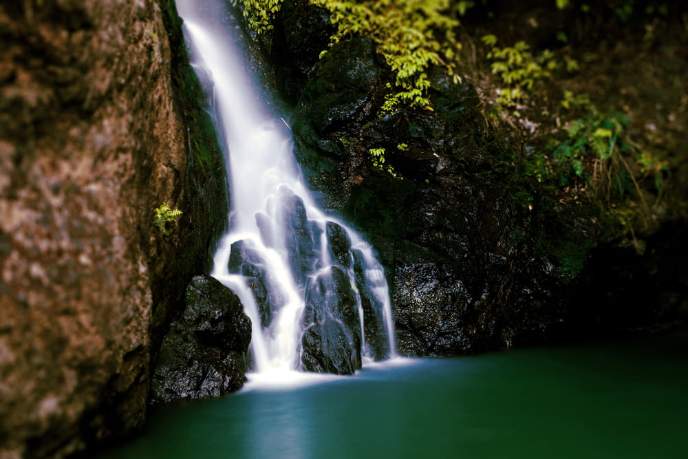 a large waterfall with green water in the middle of it