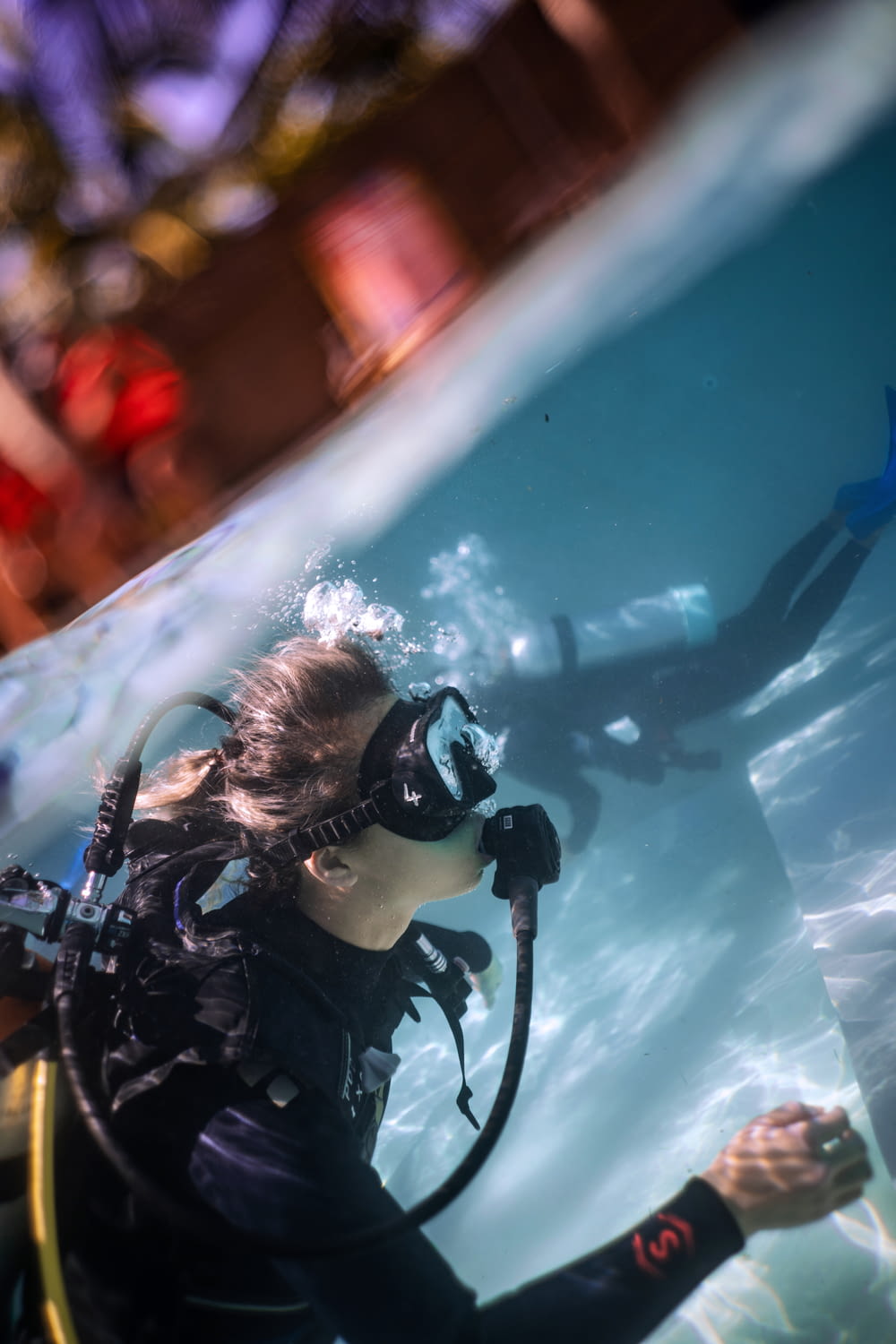 a woman scubas in the water with a scuba mask on