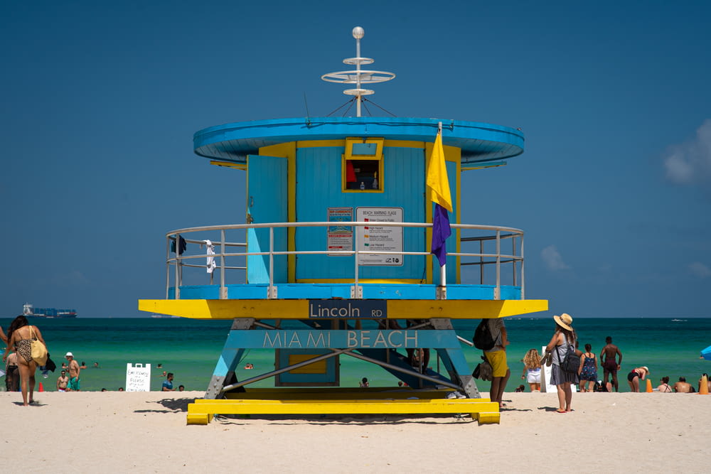 a blue and yellow lifeguard tower on a beach