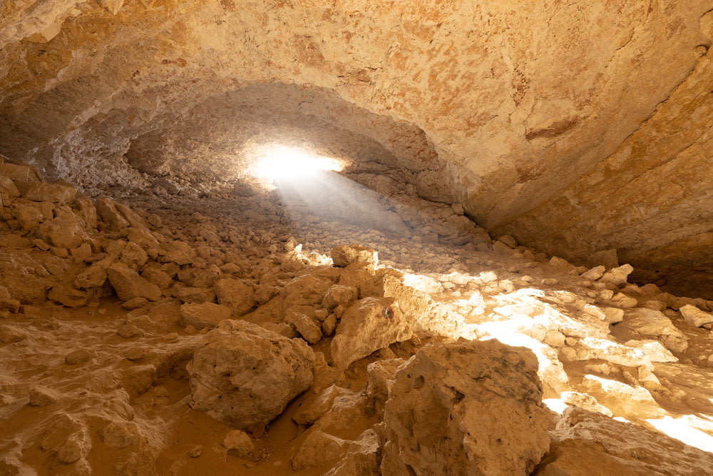 a light shines through a cave in the desert