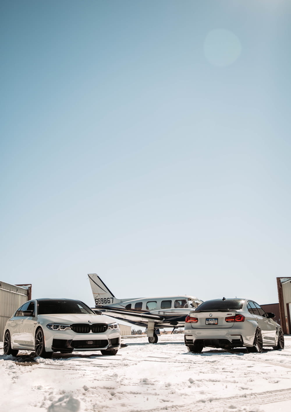 two cars parked in front of an airplane