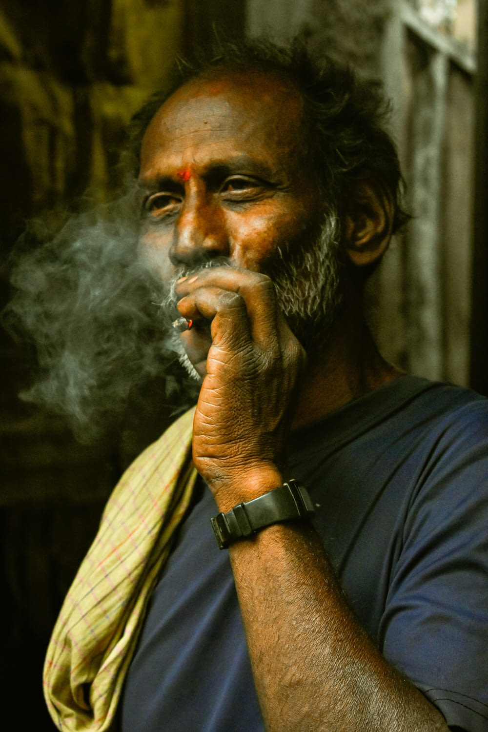 a man with a watch on his wrist smoking a cigarette