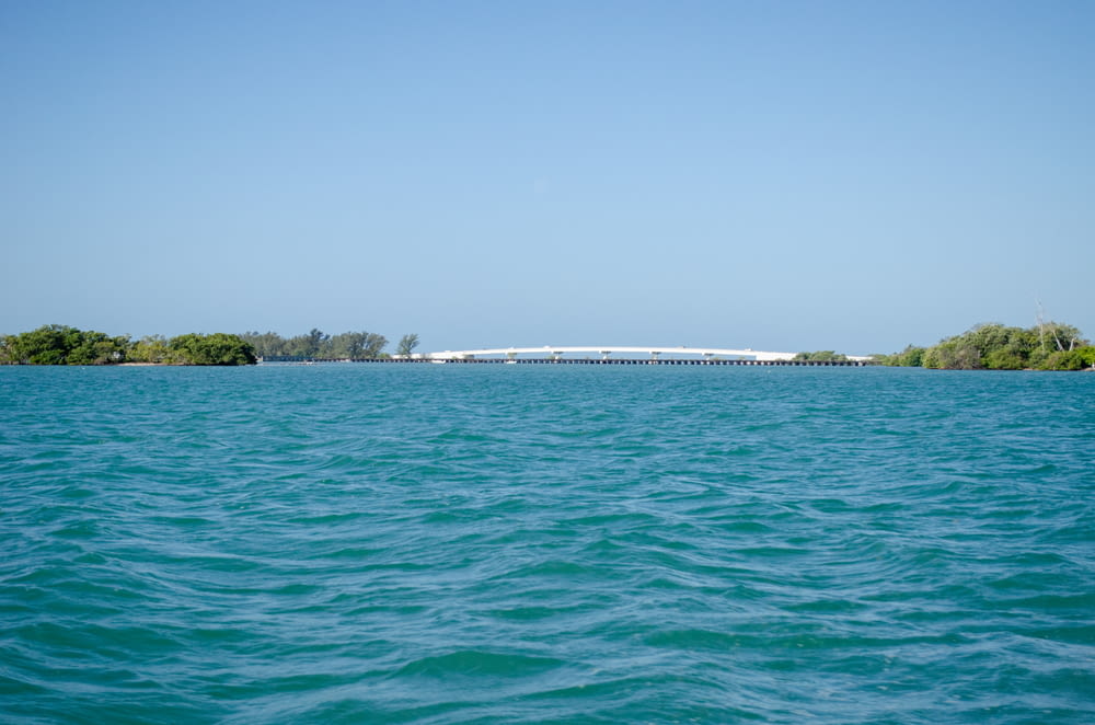 a large body of water with a bridge in the distance