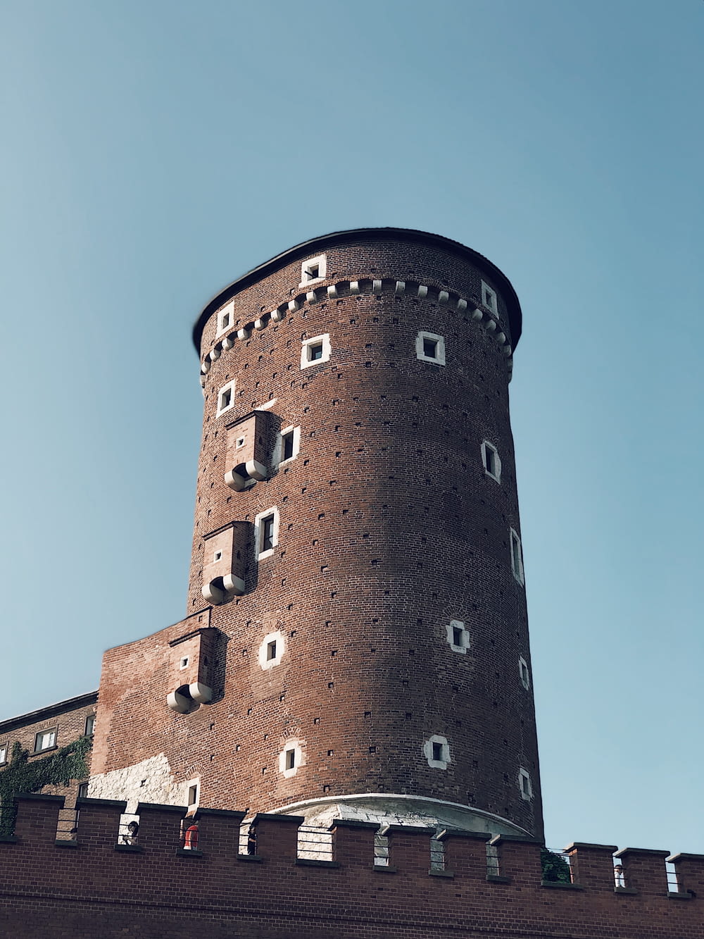 a very tall brick tower with a clock on it's side