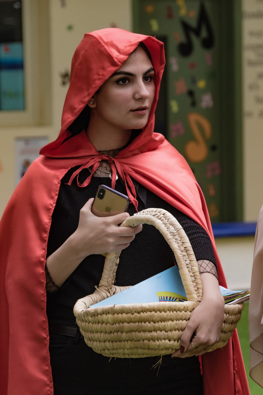 a woman in a red cape holding a basket