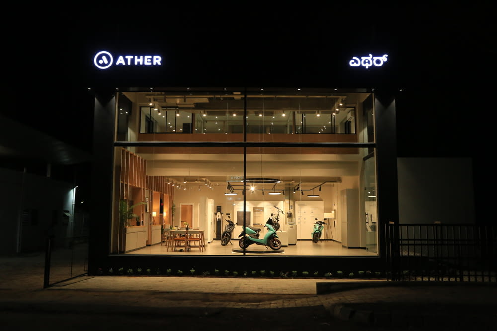 a store front at night with a person on a scooter