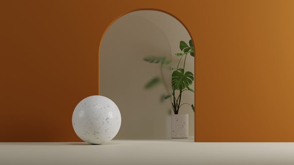 a white vase with a plant in it next to a mirror