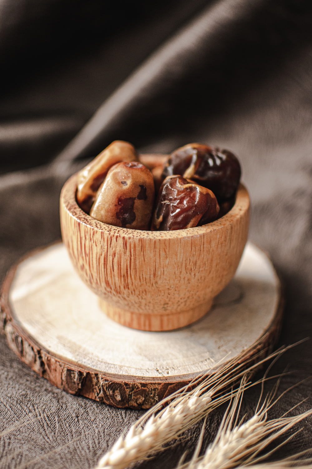 a wooden bowl filled with nuts on top of a wooden plate