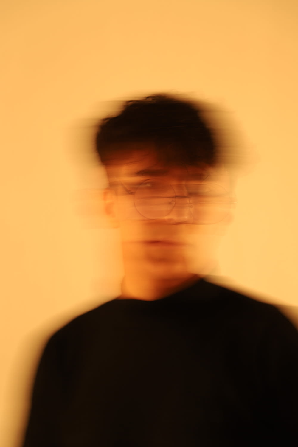 a blurry photo of a man wearing glasses