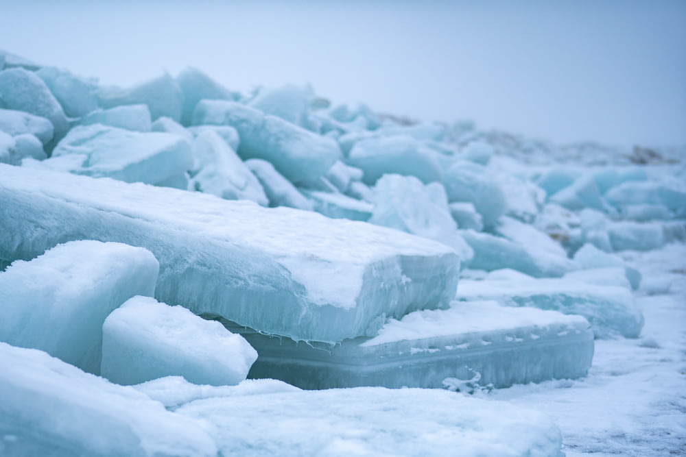 a pile of ice blocks sitting on top of a beach
