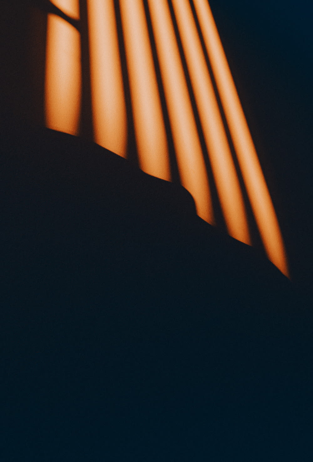 Una foto negra y naranja de una luz que entra por una ventana