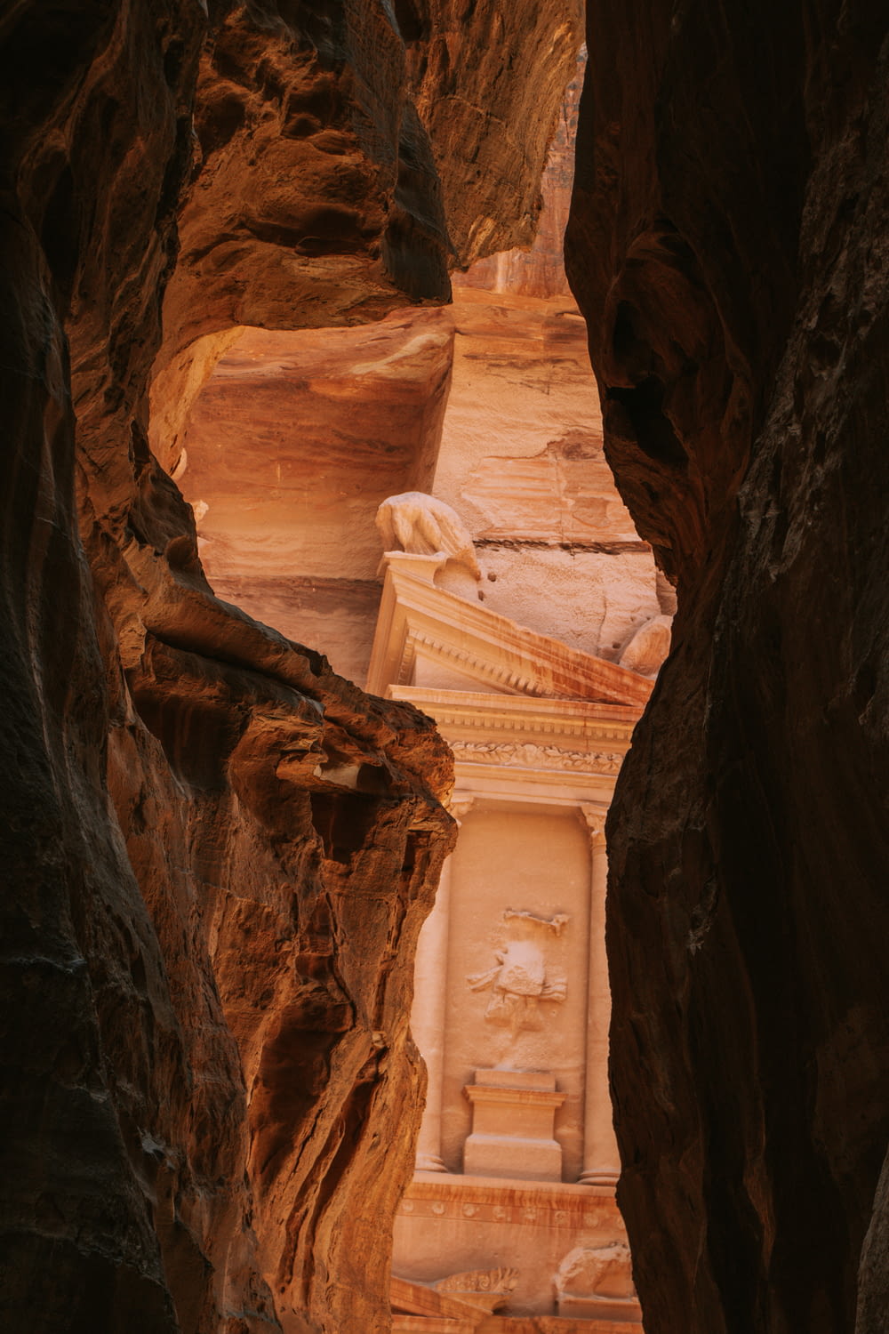 a narrow canyon with a statue in the middle of it