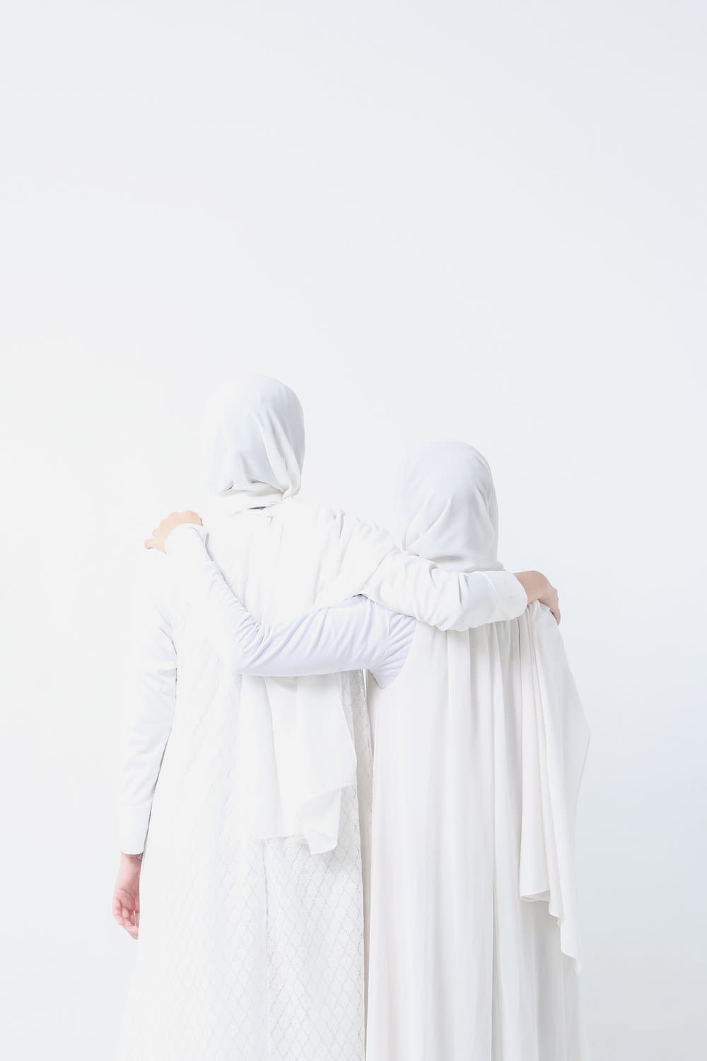 two women dressed in white standing next to each other