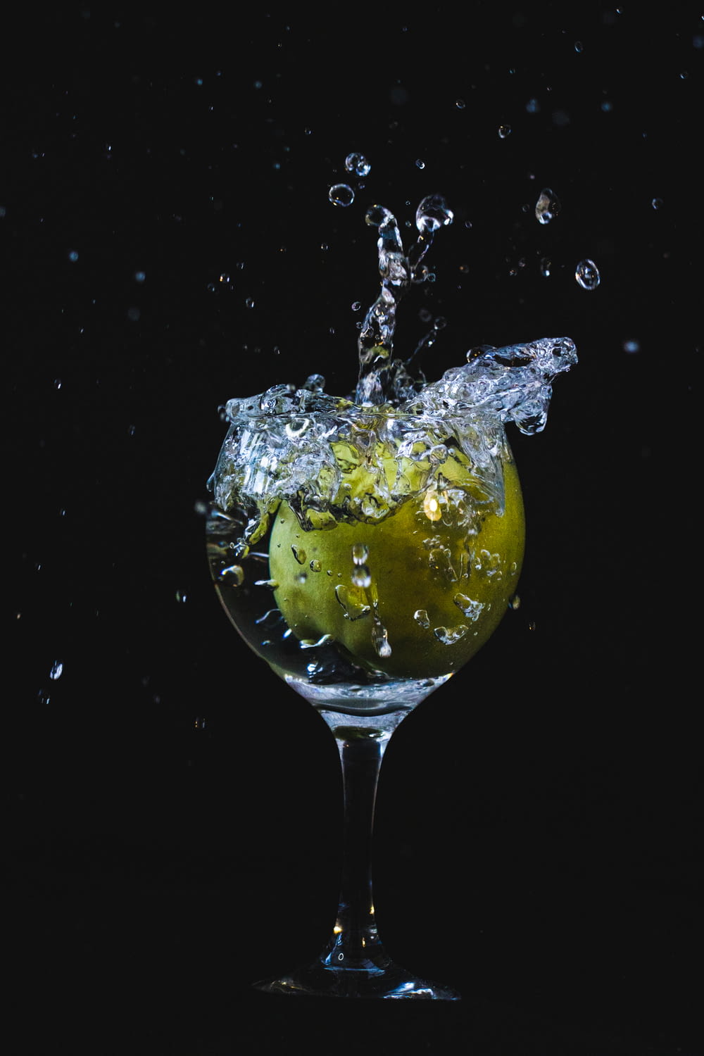 a glass filled with water and an apple