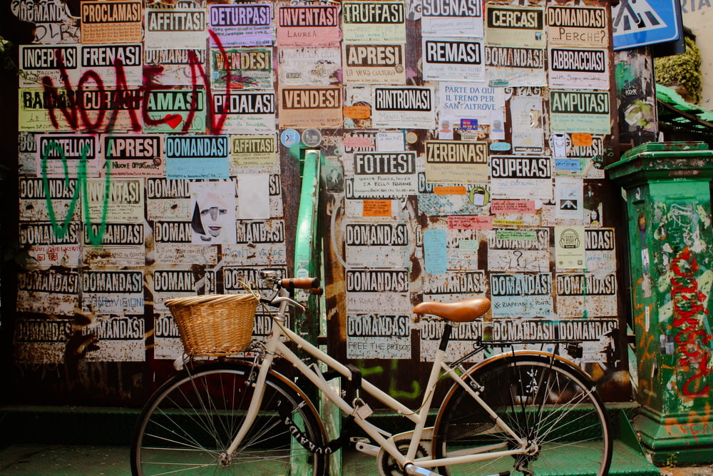a bicycle parked in front of a wall covered in signs