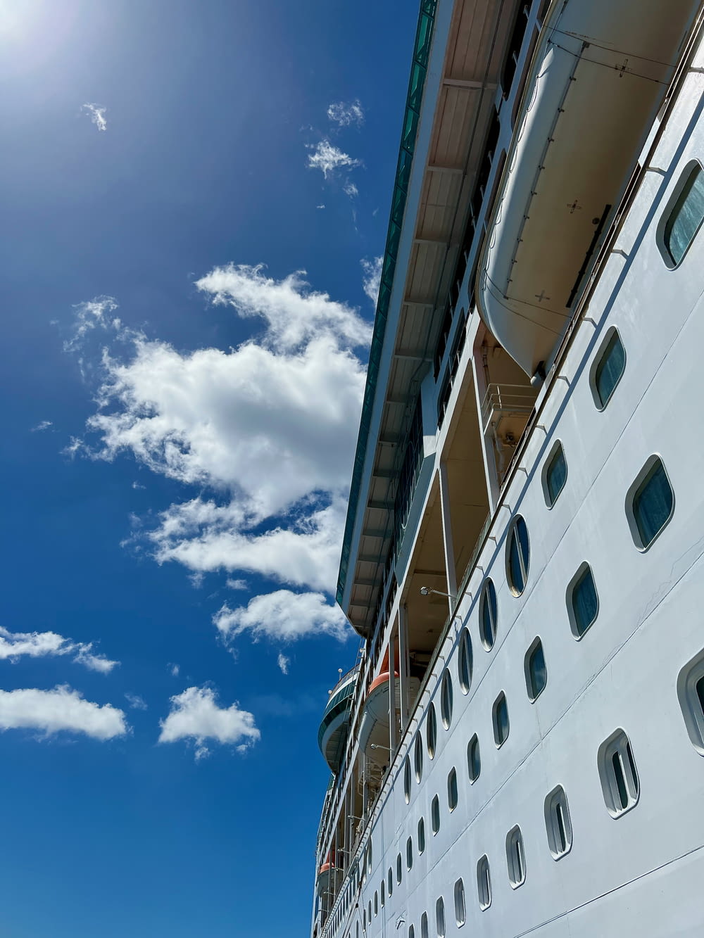 a large cruise ship under a partly cloudy blue sky