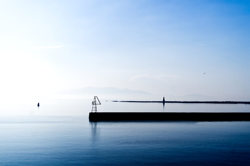 a large body of water sitting under a blue sky