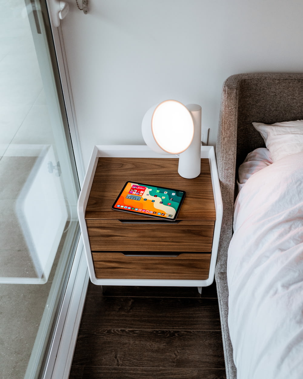 a bedside table with a phone on top of it