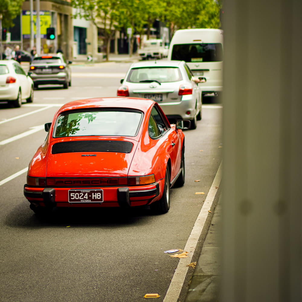a red porsche parked on the side of the road