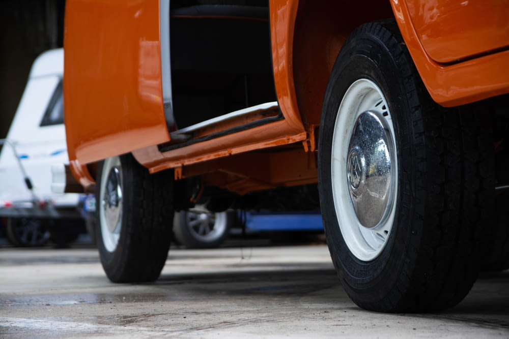 a close up of the front wheels of an orange truck
