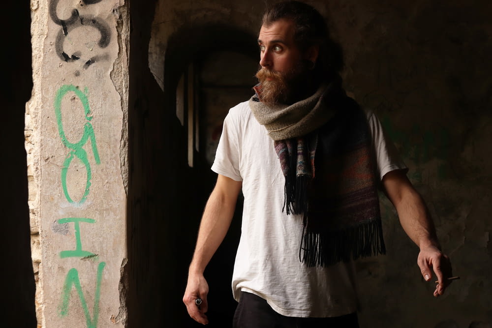 a man with a beard and scarf standing in a doorway