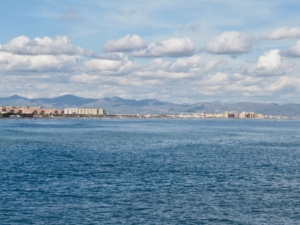 a large body of water with a city in the background