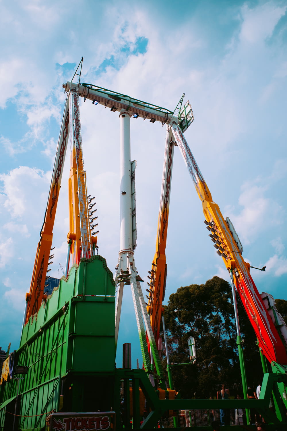 a green and white roller coaster on a cloudy day