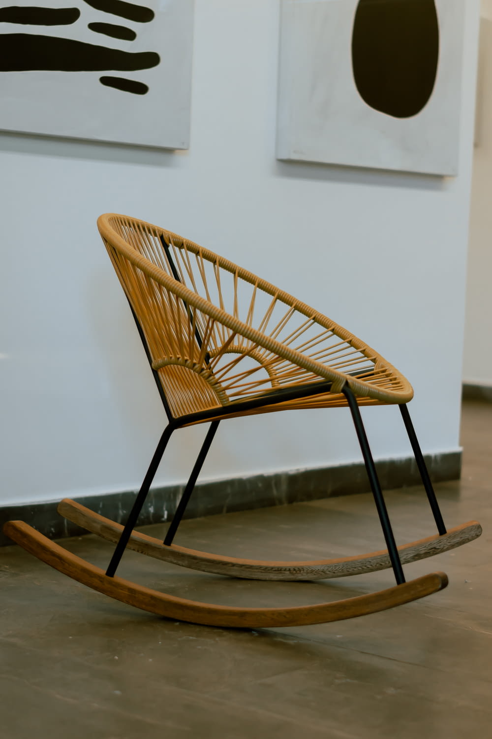 a wicker rocking chair sitting in front of a wall