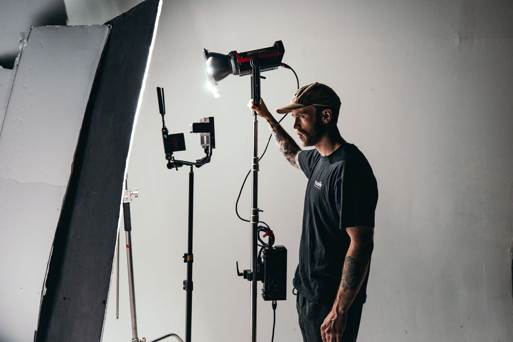 a man standing in front of a camera and lighting equipment