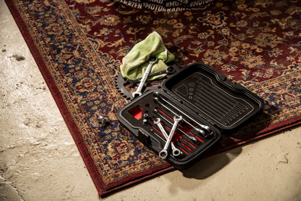 a tool box with tools inside of it on a rug