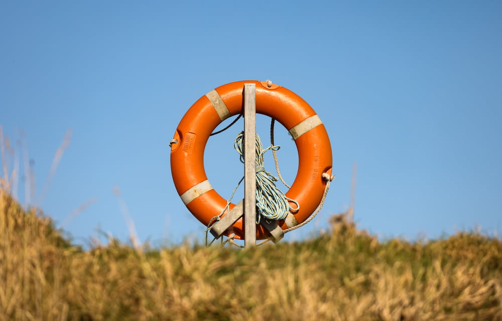 an orange life preserver hanging from a pole