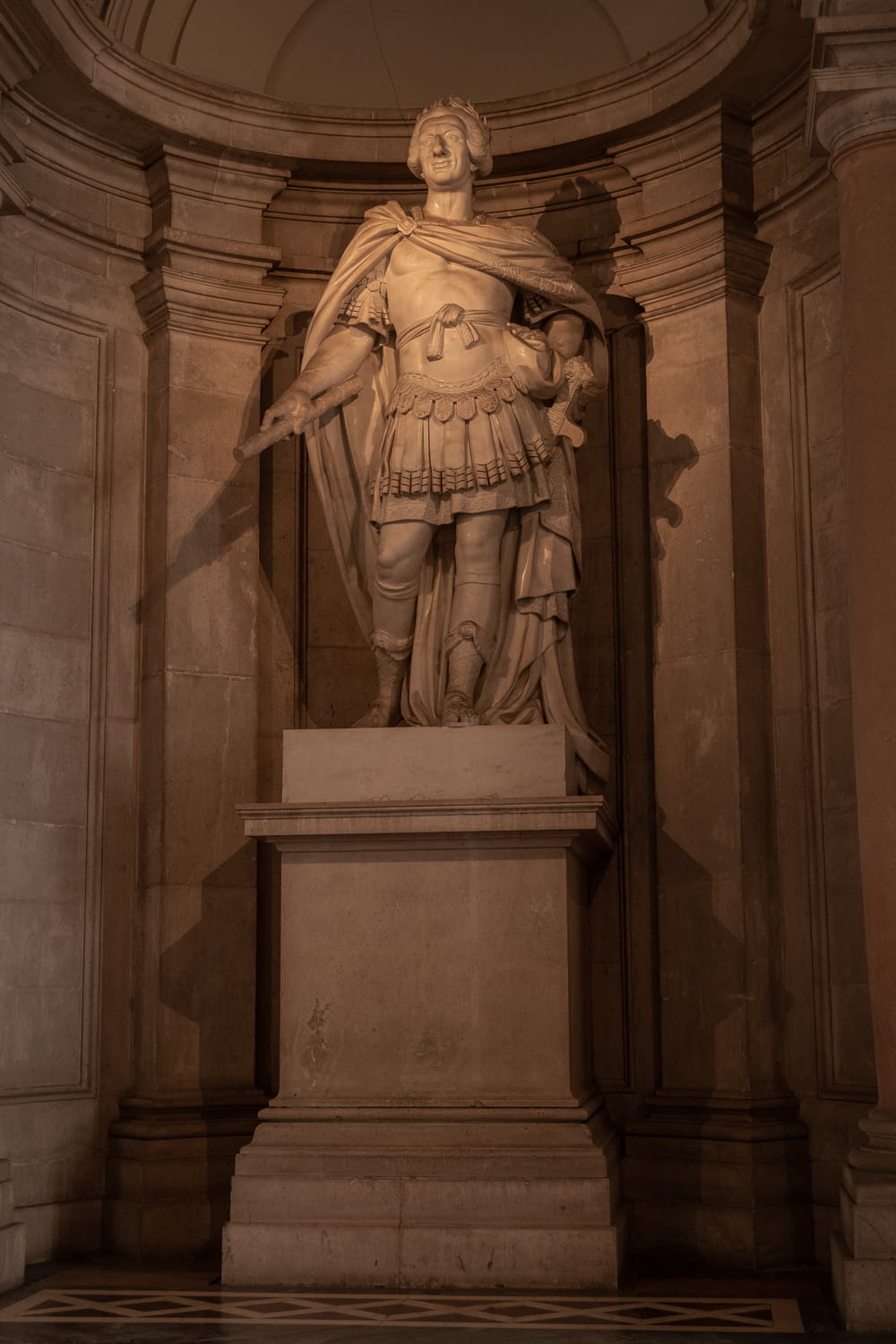 a statue of a man with a cape in a room