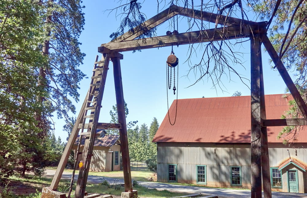 a wooden swing set in front of a building