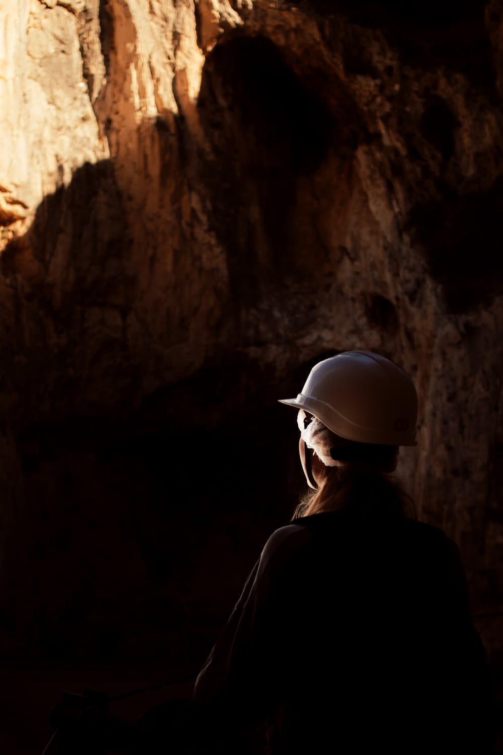 a person wearing a helmet standing in a cave