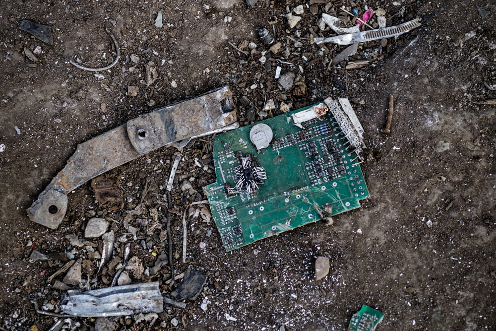 a broken circuit board laying on the ground