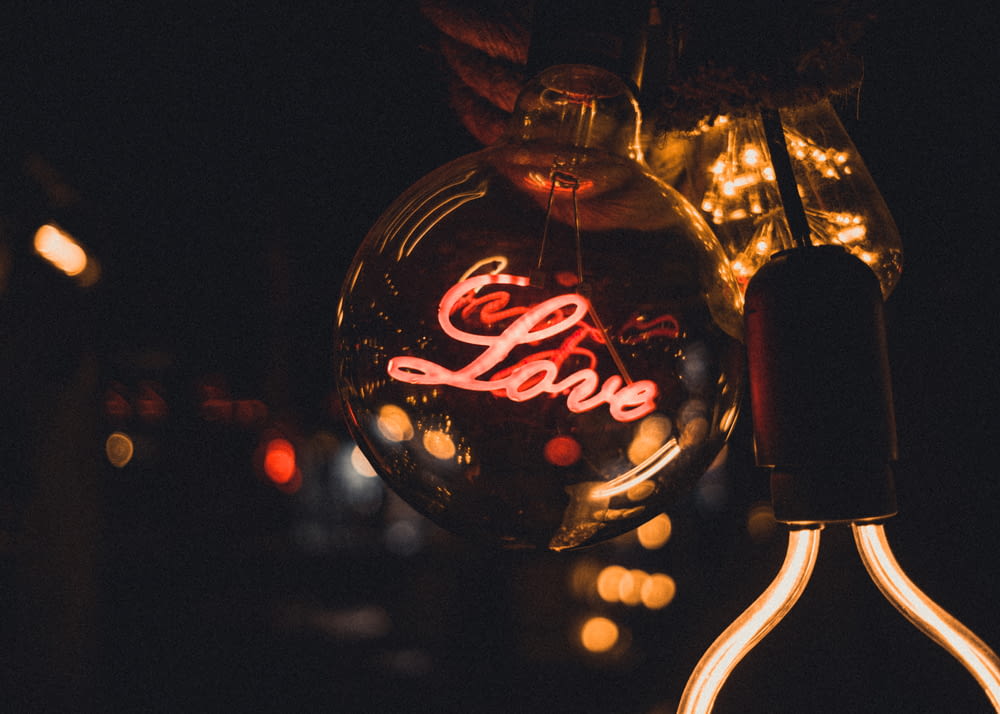 a glass ornament with the word love written on it